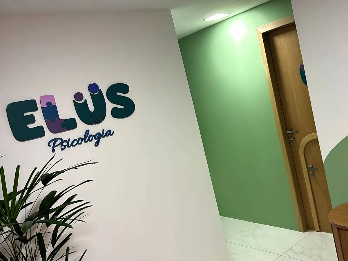 Recepção da ELUS Psicologia com poltronas, plantas e identidade visual da clínica